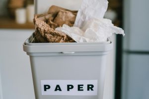 Paper waste in recepticle. Concept of recycling and need for digital transformation.