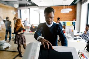 worker is printing a file , document in the office room. Accounting concept