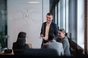 Business team discussing AI strategy and defining goals in a conference room with a whiteboard diagram.