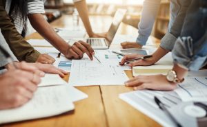 Business people, collaboration and paperwork with hands, statistics and trends. Accessibility of data to staff.