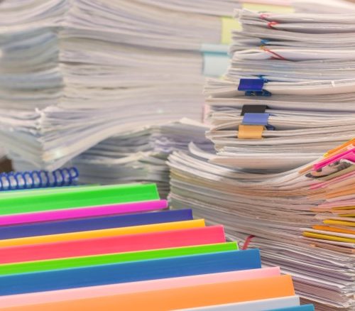 piles of papers on a school desk